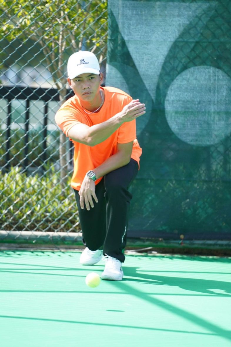 男人拿着球拍在球场上打球描述已自动生成